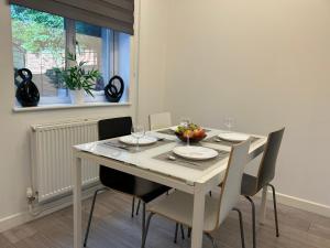 mesa de comedor blanca con sillas y ventana en Modern 3 Bedroom House, Free Parking in Oxford, en Oxford