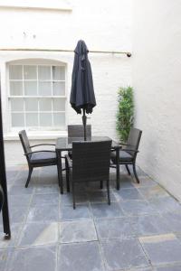 a table and chairs with an umbrella on a patio at Paddington Patio Apartment in London