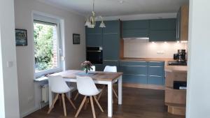 een keuken met een houten tafel en witte stoelen bij Ferienwohnungen Liedtke in Behringen