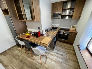 eine kleine Küche mit einem Holztisch und Stühlen in der Unterkunft Lotila Flats L'Infiestu in Infiesto + 27 Fotos