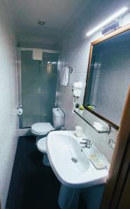 bagno con 2 servizi igienici, lavandino e specchio di Mirage Place B&B a Catania
