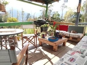 un patio con mesa, sillas y sofá en HOSTAL CASA DE GUADUA/ THE BAMBOO HOUSE, en Choachí