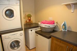 uma cozinha com uma máquina de lavar roupa e um cesto no balcão em Anne's Cottage em Bantry