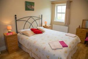 a bedroom with a bed with two pillows on it at Anne's Cottage in Bantry