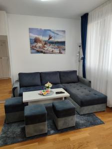 een woonkamer met een bank en een salontafel bij Apartman LUXNS Novi Sad in Pasuljište