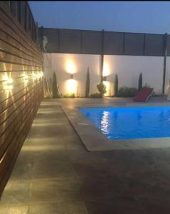 una piscina notturna con luci accese su un edificio di Cozy Farm ad Amman