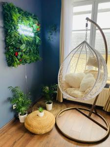 a swing in a room with potted plants at Grand studio avec spa, cosy et rénové au cœur de Soissons in Soissons