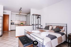 a bedroom with a large bed and a kitchen at Flat Mazzini 6 in Alzano Lombardo