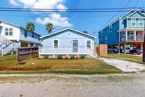 Biały dom z gankiem i niebieskim domem w obiekcie Out of the Blue w mieście Galveston