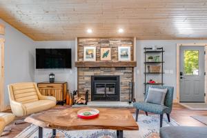 Anvil Lake Lodge في إيغل ريفير: غرفة معيشة مع موقد وتلفزيون