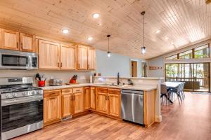 une cuisine avec des placards en bois et des appareils en acier inoxydable dans l'établissement Anvil Lake Lodge, à Eagle River