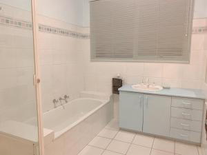 a white bathroom with a tub and a sink at The peaceful retreat in Mulgrave +17 photos