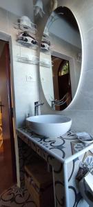 a bathroom with a white sink and a mirror at La Casina di Nonna Lola in Castiglione dʼOrcia