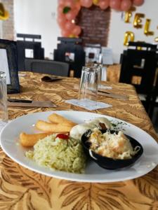 HIDALGO HOTEL في بالميرا: طبق من الطعام مع الأرز ورقائق على الطاولة