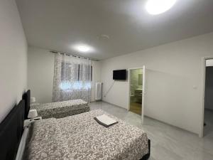 um quarto de hotel com duas camas e uma televisão em Casa Roma rooms&apartments em Pádua