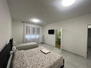 パドヴァにあるCasa Roma rooms&apartmentsのベッド2台とテレビがあるホテルの部屋