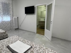 パドヴァにあるCasa Roma rooms&apartmentsの白いリビングルーム(テレビ、ドア付)