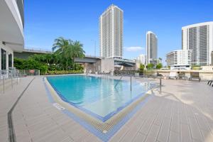 a swimming pool with chairs and buildings in the background at Hallandale Sky Water View in Hallandale Beach