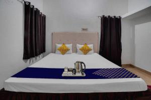 a room with a bed with a blue and white bedspread at OYO Hotel Rudraksh Residency in Bhilai