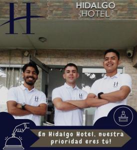 HIDALGO HOTEL في بالميرا: مجموعة من ثلاثة رجال واقفين وذراعهم مشقوقة