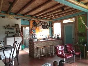cocina con mesa, sillas y barra en HOSTAL CASA DE GUADUA/ THE BAMBOO HOUSE, en Choachí