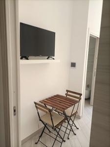 een kamer met een tafel en een televisie aan de muur bij Rooms add e criatur in Napels