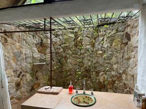 a bathroom with a sink and a stone wall at Paraíso campestre cerca a Cali in Papagalleros +10 photos
