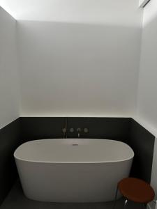 La salle de bains est pourvue d'une baignoire blanche et d'un tabouret. dans l'établissement Luxury flat - Paris - Eiffel Tower - 2 rooms, à Paris