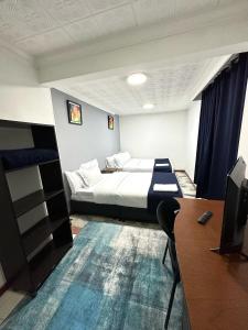 um quarto de hotel com uma cama, uma secretária e uma televisão em Way Maker sede 2 em Bogotá