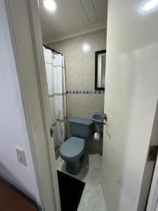 uma casa de banho com um WC azul e um lavatório. em Way Maker sede 2 em Bogotá