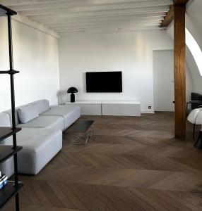 - un salon avec un canapé et une télévision murale dans l'établissement Luxury flat - Paris - Eiffel Tower - 2 rooms, à Paris