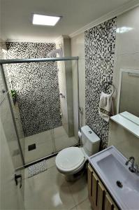 a bathroom with a shower and a toilet and a sink at Apto Familiar Completo, 2 quartos in Porto Alegre