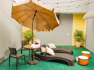 a patio with a table and an umbrella at KANKUN MOTEL E POUSADA -Adult only in Sorocaba