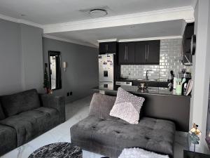 een woonkamer met een bank en een keuken bij 404 on 9 Palm Blvd in Durban