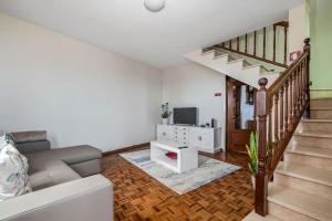 een woonkamer met een bank en een televisie bij De Freitas Home in Porto Moniz