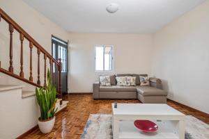 een woonkamer met een bank en een tafel bij De Freitas Home in Porto Moniz