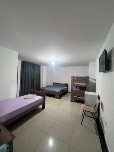 a room with two beds and a desk and a chair at Hotel Palace Struga in Struga