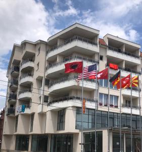 un edificio con banderas volando delante de él en Hotel Palace Struga, en Struga