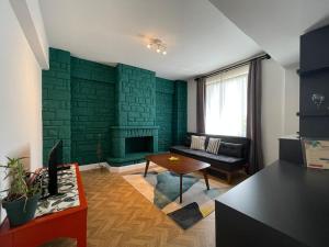 een woonkamer met een groene bakstenen muur bij Cabbana Hotel Lara in Antalya