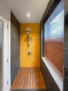 a shower with a yellow brick wall and a window at Cabbana Hotel Lara in Antalya