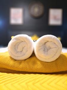 a pair of towel rolls sitting on a bed at Professional Stay Doctors Nurses Trades in Luton