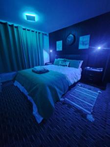 - une chambre avec un grand lit dans une pièce sombre dans l'établissement Professional Stay Doctors Nurses Trades, à Luton