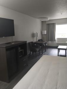 een hotelkamer met een televisie en een woonkamer bij Quality Inn & Suites Wilsonville in Wilsonville