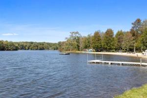a view of a lake with a dock and a beach at Rustic Luxury in the Pocono Mountains - Stag Lodge in Pocono Lake