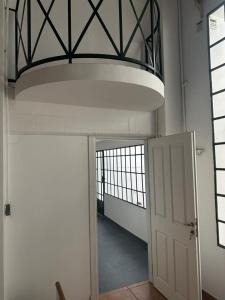 a hallway with a white door and a large ceiling at Casa en el Encantador San Telmo - 8 habitaciones in Buenos Aires