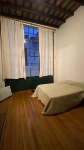 a bedroom with a bed and a large window at Casa en el Encantador San Telmo - 8 habitaciones in Buenos Aires