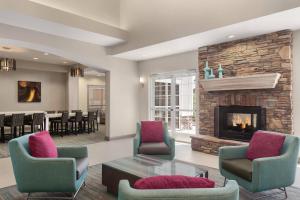 a living room with two chairs and a fireplace at Residence Inn By Marriott Las Vegas Stadium Area in Las Vegas