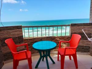 a table and two chairs on a balcony with the ocean at Flores casas de playa in Alexandria