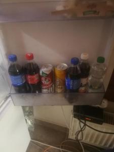 Un estante con un montón de botellas de soda. en Vila Barrandov, en Praga