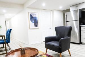 a living room with a chair and a table at Garden Ave Suite 3 Mins to Hwy 403 in Brantford